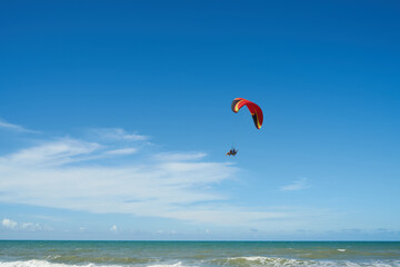 Hang glider flying over the beach. 해변 위를 날고 있는 행글라이더