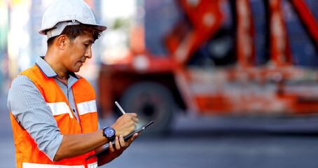 Asian male warehouse engineer working in container yard.