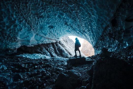 Man silhouette in crystal ice blue cave