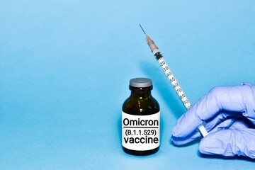 Injectable vaccine for the vaccination program of coronavirus Omicron. Doctor holds the hand Vaccine vial and syringe to administer vaccination doses for New Variant of the Covid-19 Omicron B.1.1.529 
