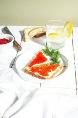 Sandwiches with red caviar on a white plate