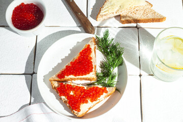 Sandwiches with red caviar on a white plate