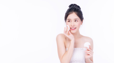 Glamour asian young woman holding white cotton pad removing make-up on white background. Model...