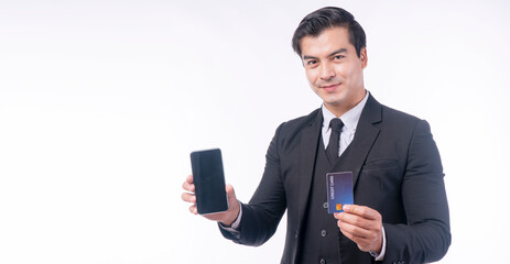 Success handsome businessman showing credit card holding mobile phone standing over isolated white...