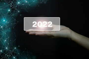 Closeup hands holding 2022 virtual screen, new year concept.