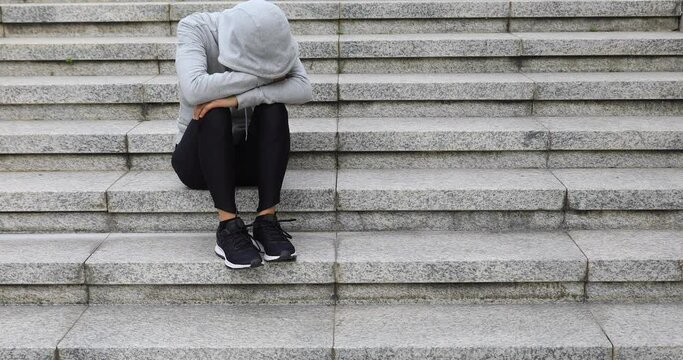 Upset woman sitting alone in city stairs