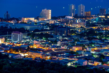 Fototapeta premium The high angle background of the city view with the secret light of the evening, blurring of night lights, showing the distribution of condominiums, dense homes in the capital community