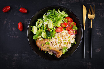 Healthy salad with chicken leg, tomatoes,  cucumber and lettuce  on dark background. Healthy lunch. Dietary menu. Top view