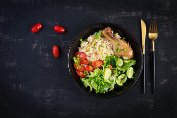 Healthy salad with chicken leg, tomatoes,  cucumber and lettuce  on dark background. Healthy lunch. Dietary menu. Top view