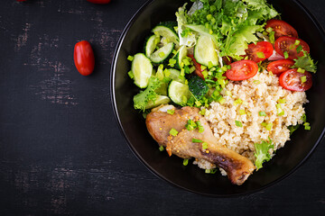 Healthy salad with chicken leg, tomatoes,  cucumber and lettuce  on dark background. Healthy lunch. Dietary menu. Top view