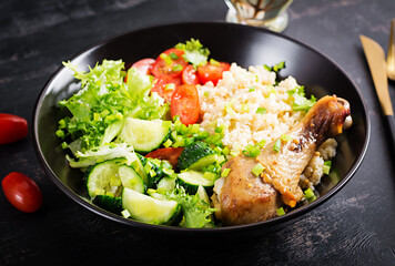 Healthy salad with chicken leg, tomatoes,  cucumber and lettuce  on dark background. Healthy lunch. Dietary menu.