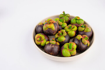 Mangosteen with ceramic plate on white background.