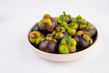 Mangosteen with ceramic plate on white background.