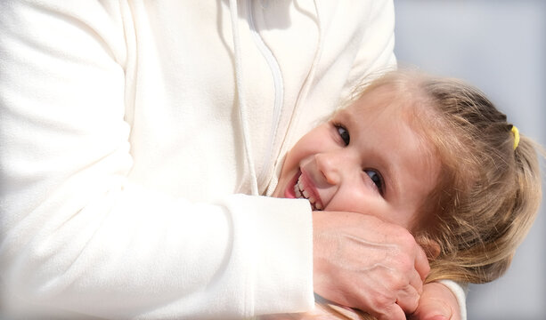 Loving grandmother hugging her granddaughter. Happy family.  Having good times with grandparent outdoors