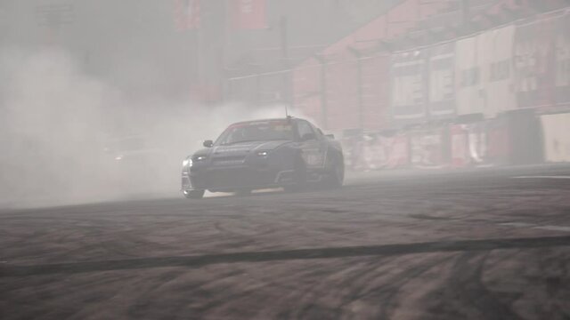 Race drift car burning tires on motorsport track. Footage. Smoky video from the real track of the day with many races
