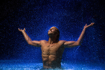 Obraz premium Muscular man in water under the rain