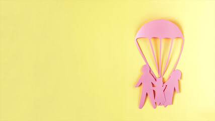 Abstract cardboard family of three and a rescue parachute. The concept of family protection in various situations.