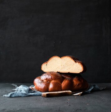 Hala bread. Traditional Jewish challah bread with poppy seeds on a black background with space for text. 