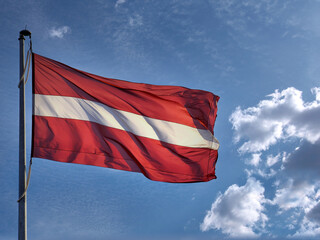 Flag of the Republic of Latvia. Flag of Latvia against the blue sky. Copy space.