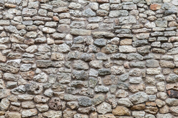 Old gray rough stone wall. Close up