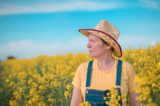 Portrait of female farmer agronomist in blooming rapeseed crops field