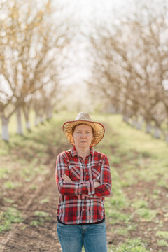 Portrait of female farmer with her arms crossed in organic walnut orchard, sustainable farming