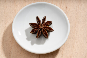 Detailed and large close up shot of star anise on a small plate