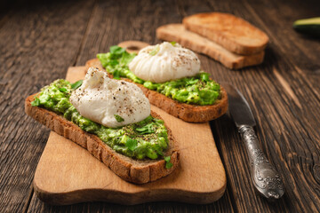Avocado toast with poached egg on cutting board