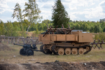 Fototapeta premium Attack of Soviet soldiers. A crawler vehicle carrying a soldier and a machine gun. Reconstruction of the battle of World War II