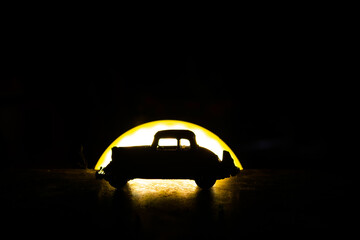 antique car silhouette against a dark sunset