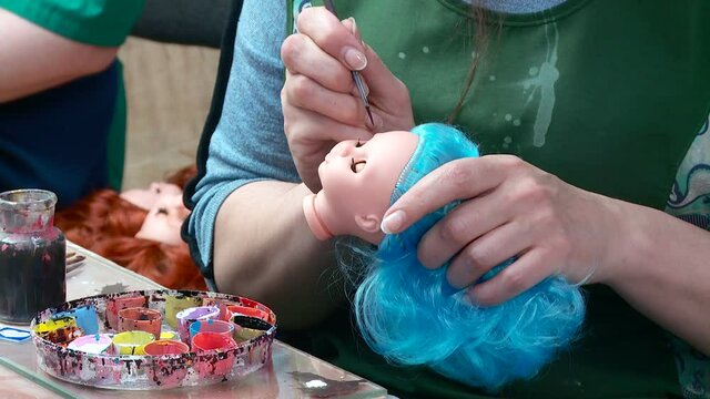 production of dolls at the toy factory hair extensions and coloring of blanks