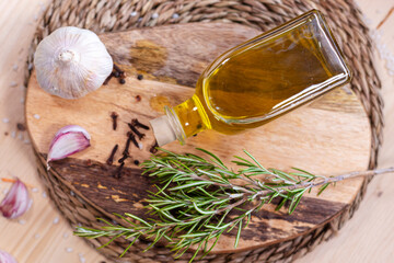 Aceite y romero en tabla de madera y tapete de Yute