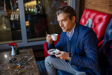 Handsome bussines man drinking coffe in the hotel lobby