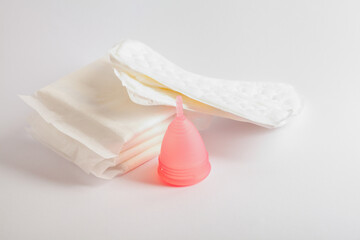 Obraz na płótnie Canvas Menstrual cup and sanitary pads, woman critical days, gynecological concept, menstruation cycle