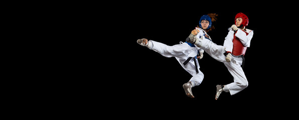 Fototapeta na wymiar Flyer with two young women, taekwondo athletes training together isolated over dark background. Concept of sport, skills