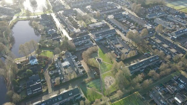 Aerial of a beautiful and calm suburban neighborhood with green parks and ponds in the Netherlands