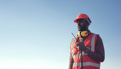 Close up Professional African-American male engineers use radio communication to communicate...