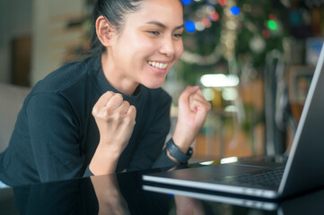 A young happy woman is surprising while using computer laptop in cafe. people and technology concept...