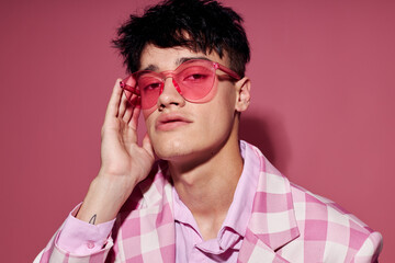 Obraz premium pretty man in pink glasses pink blazer posing studio isolated background unaltered