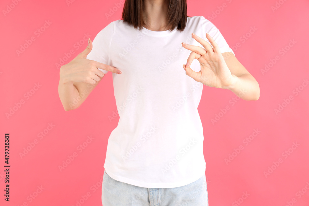 Wall mural Attractive girl in white t-shirt on pink background