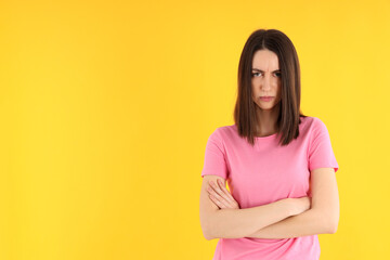 Young attractive woman in t-shirt on yellow background