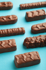 Mix of chocolate bars on blue background with copy space. Top view.