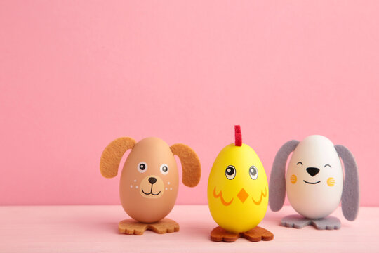 Easter holiday concept with cute handmade eggs, dogs, chicks and cat on pink background.