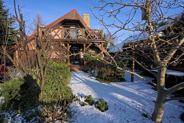 Rural house in the garden covered with snow in the winter  - obrazy, fototapety, plakaty