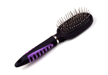 Massage comb for combing women's hair. Plastic brush with metal corners for detangling hair. On an isolated white background. Close-up.