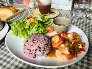 Dish of red cargo rice served with stir fried prawn and bird chili in Thailand.