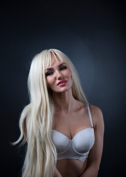 Fashionable photo of young blonde woman wearing white lingerie 