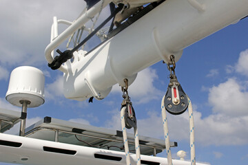 A boat GPS aerial next to the boom with rope pulleys coming off it