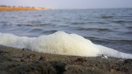 polluting white foam spume in sea water - ocean water pollution and climate change due to sea...