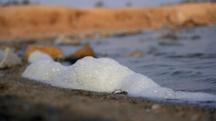 Fototapeta na wymiar polluting white foam spume in sea water - ocean water pollution and climate change due to sea warming - Spain Murcia Mediterranean Sea